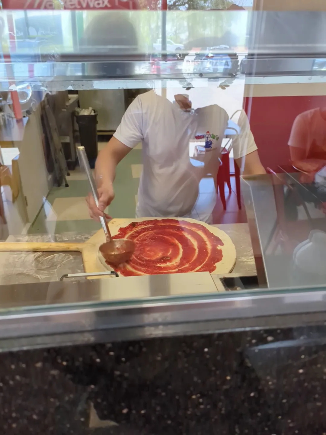 Saucing a fresh pie at the counter